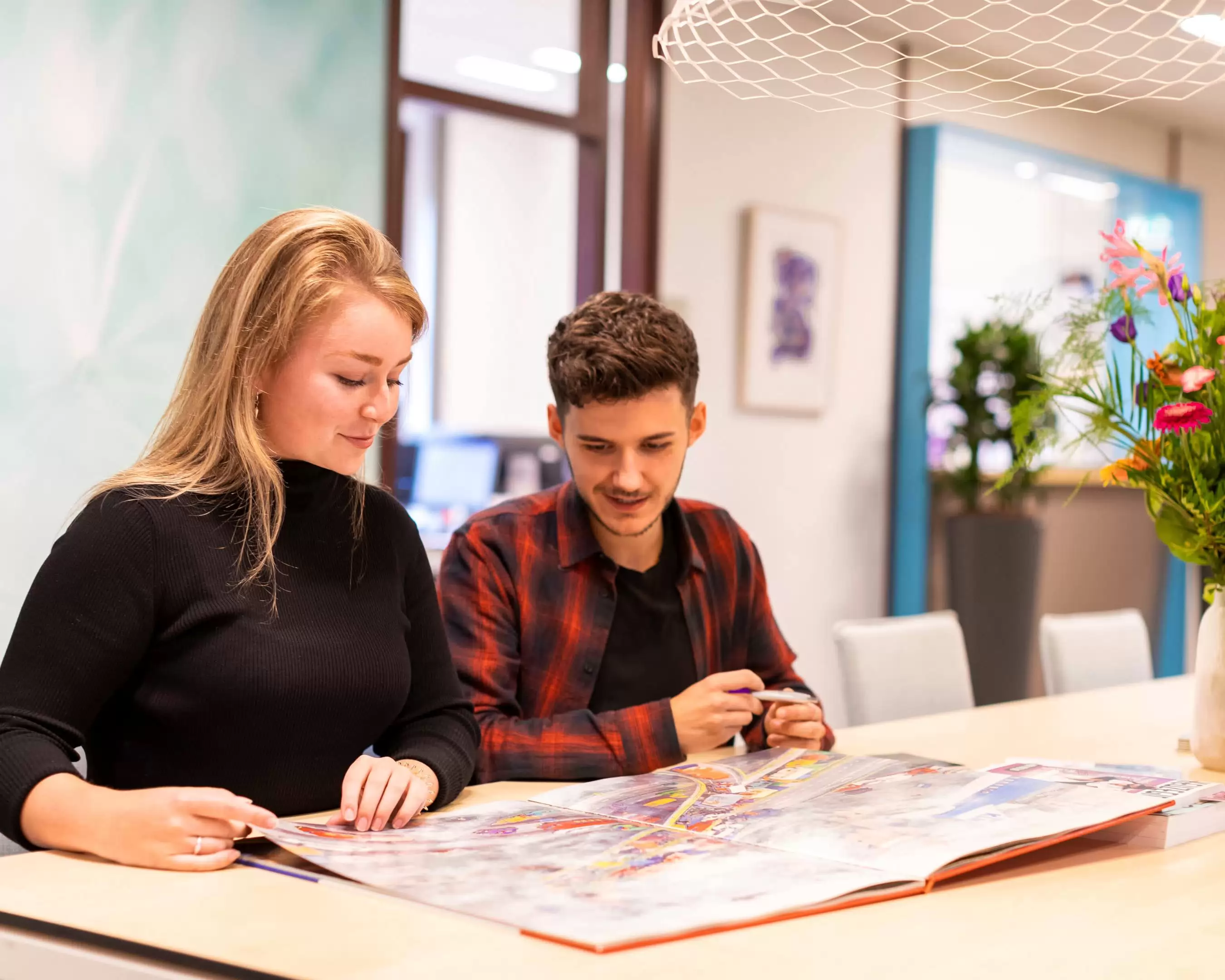 Studenten lerarenopleiding bladeren in een boek