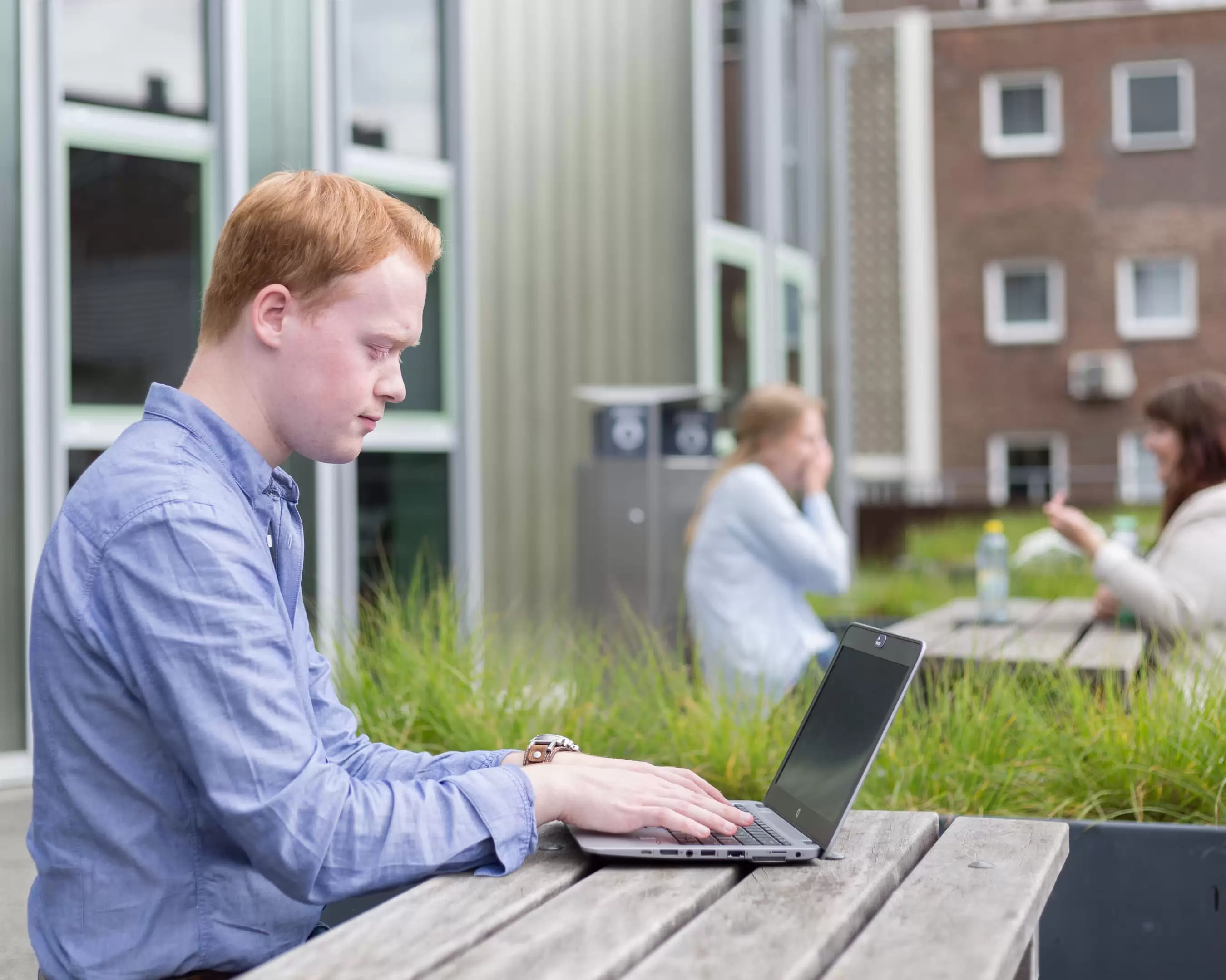 Een deeltijdstudent Leraar Biologie werkt buiten aan een laptop