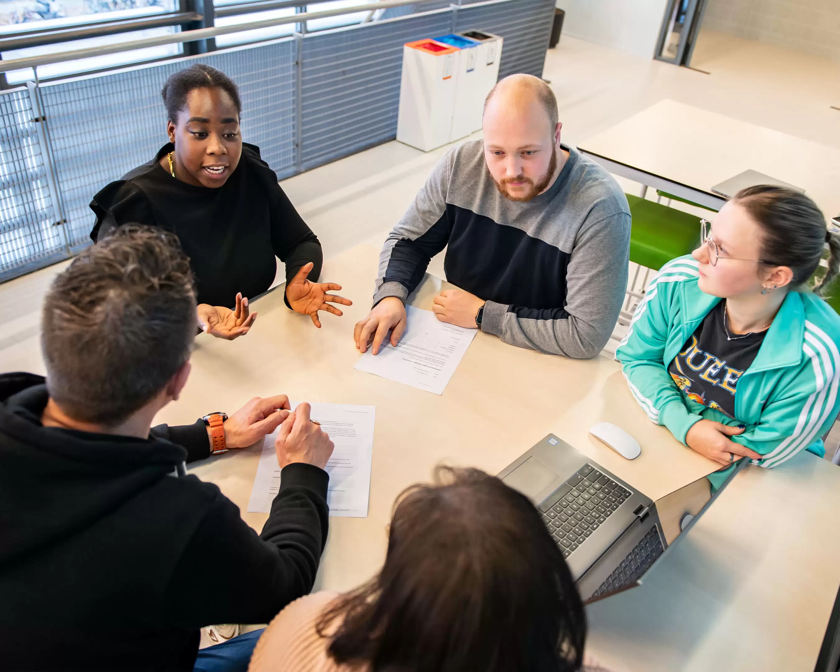 Studenten met elkaar in gesprek in een kring aan een tafel voor de masteropleiding Leraar Biologie