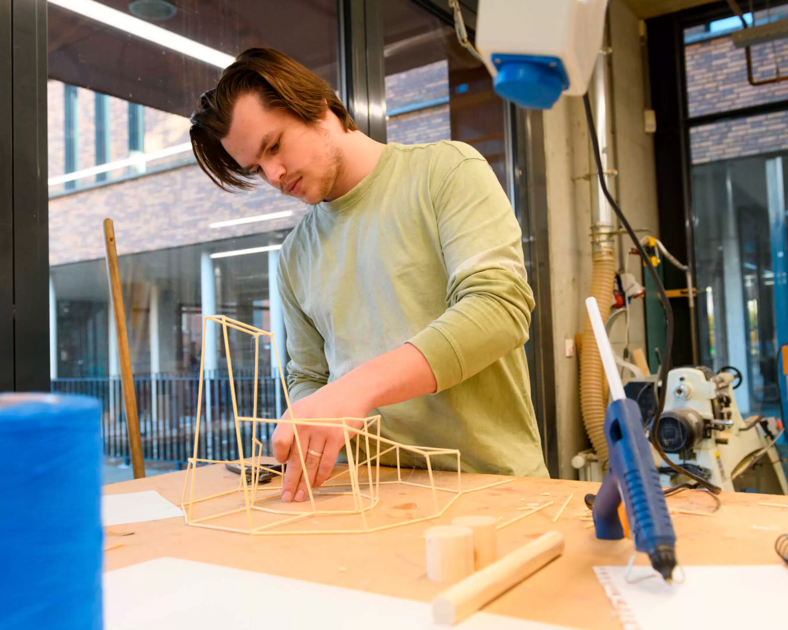 A student from the Master Architecture is working on his project in de wood workshop