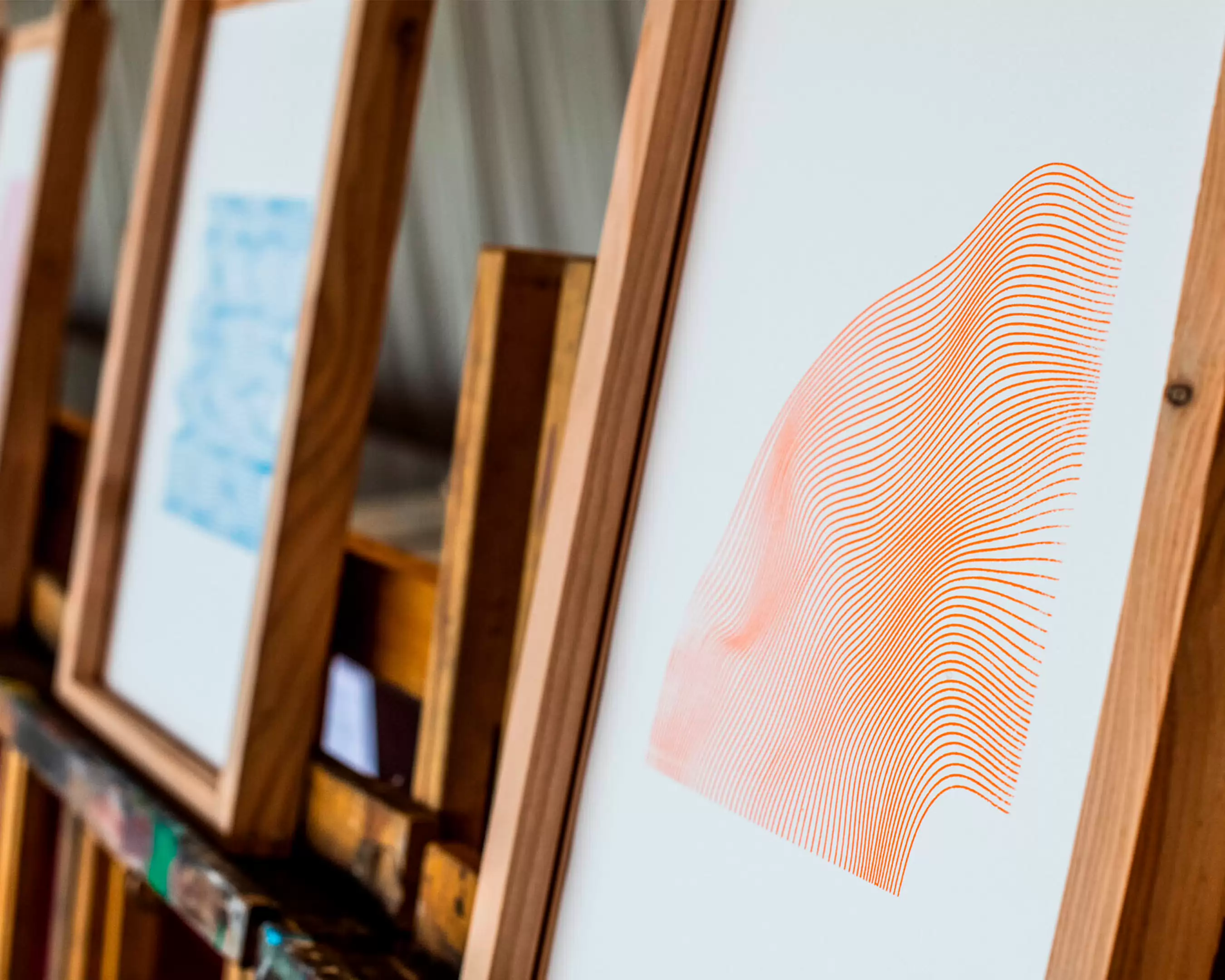 Abstract schilderij met oranje lijnen in een houten lijst.