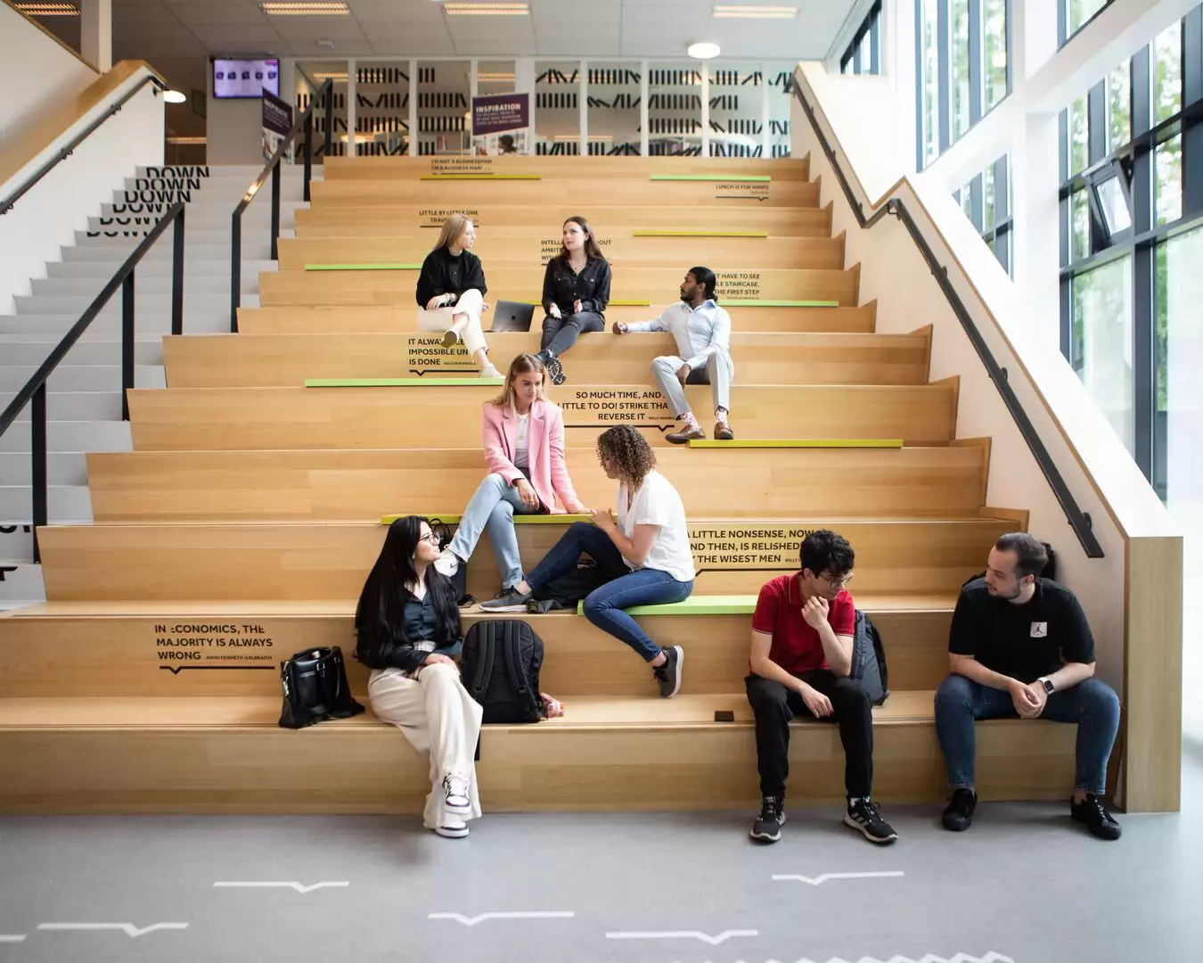 Studenten van opleiding Commerci&euml;le Economie zitten samen op de trap