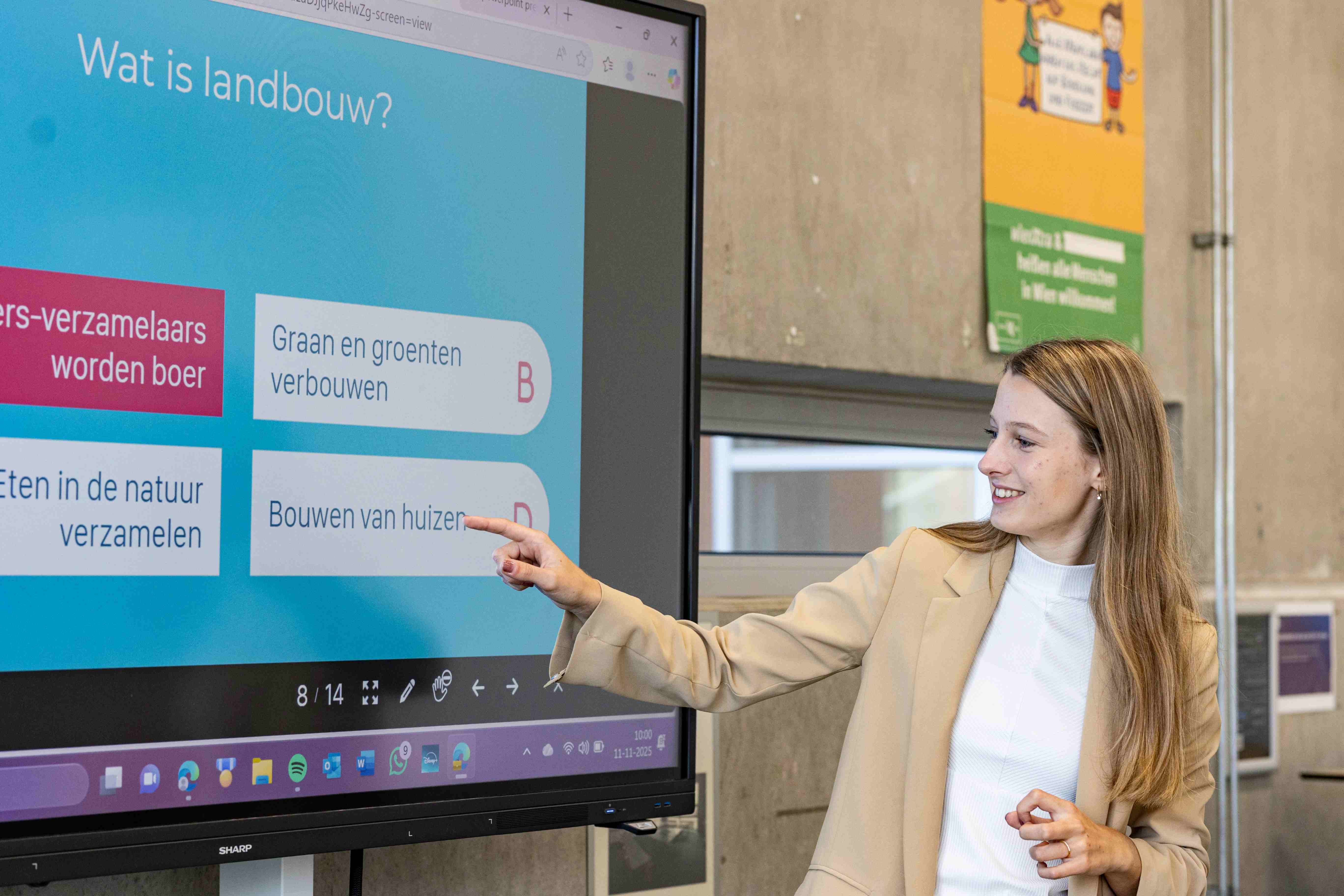 Docente Aardrijkskunde wijst aan op digibord