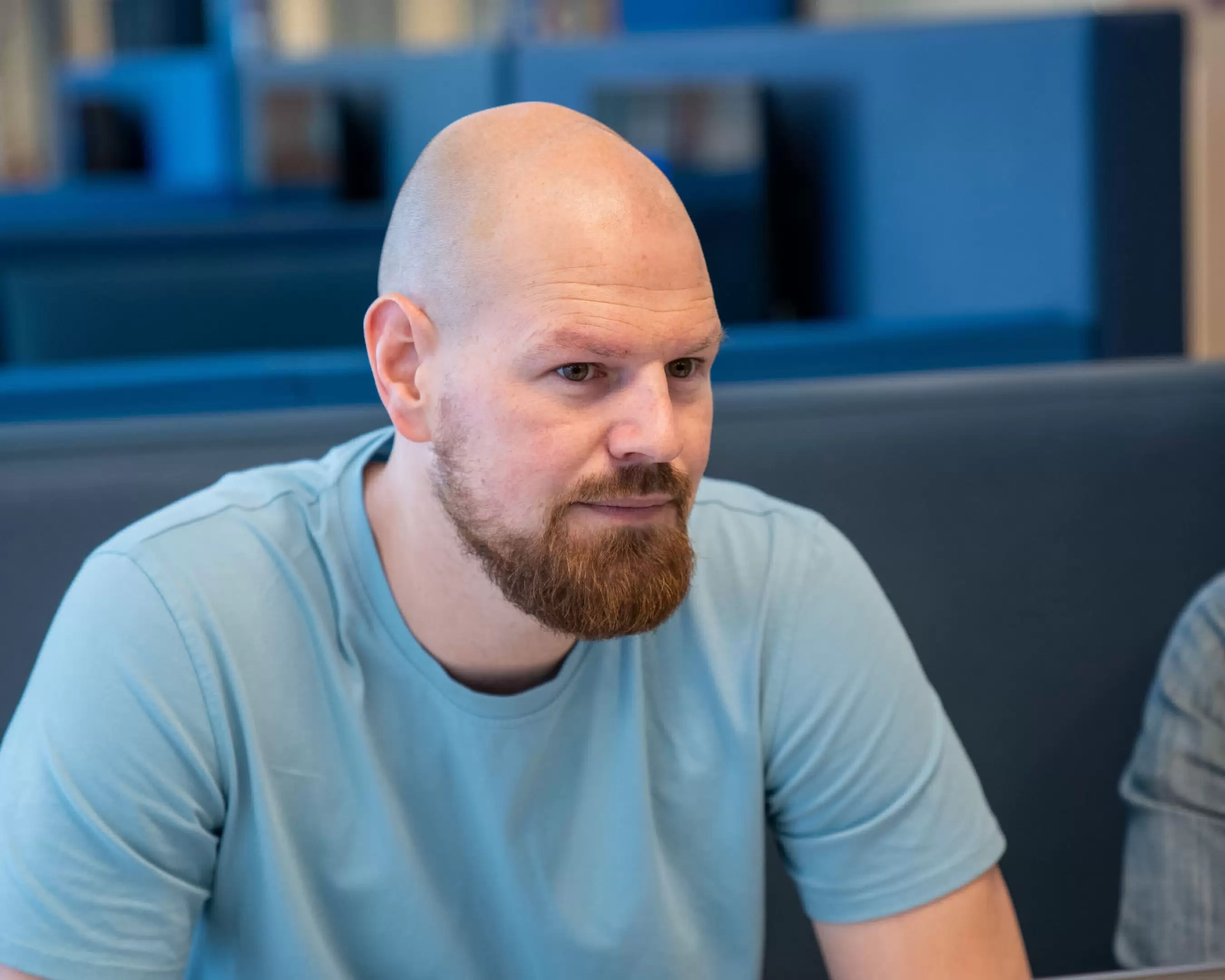 Student zit in de bank en luistert voor de opleiding Leraar Duits.