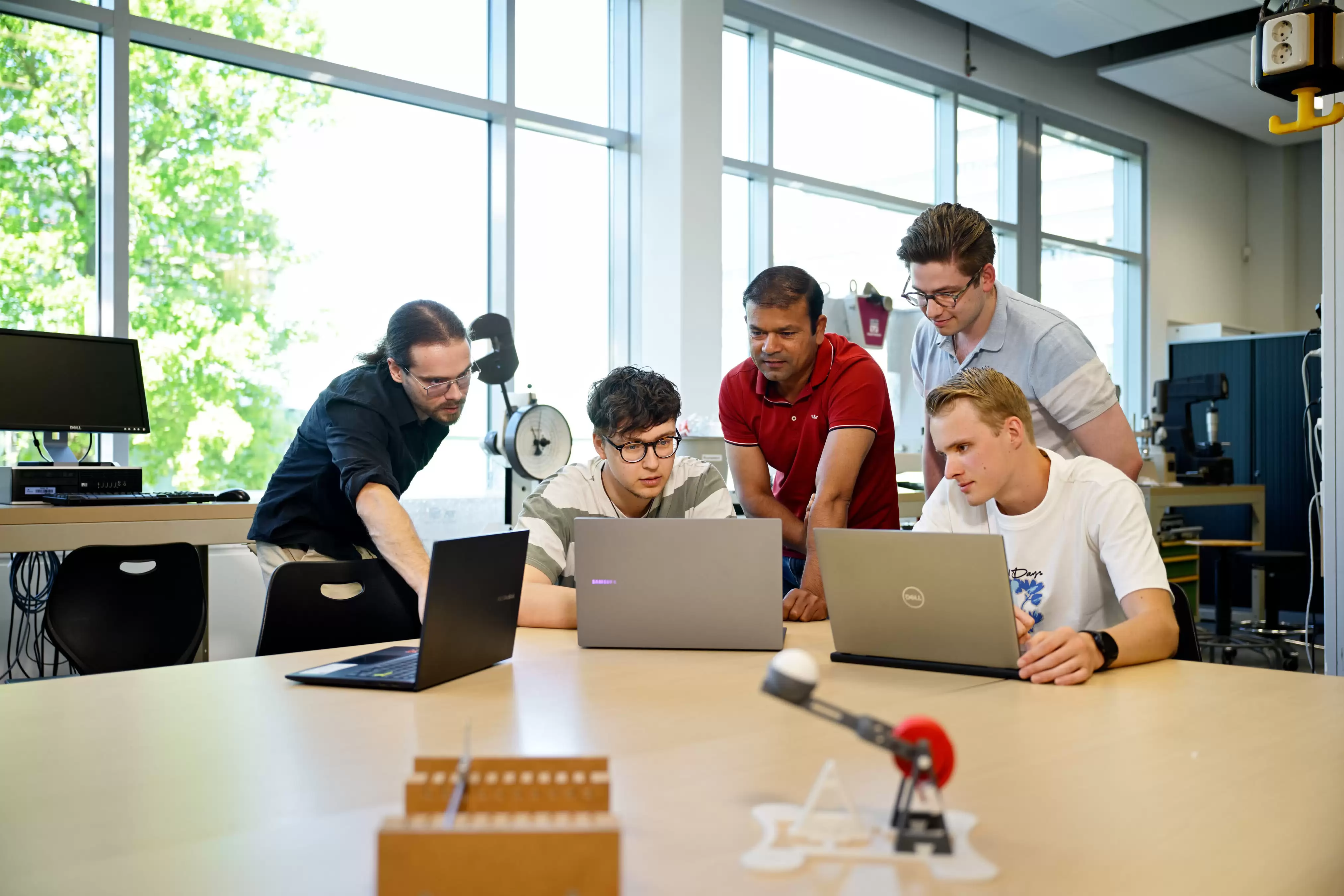 Studenten werktuigbouwkunde ad kijken in de camera