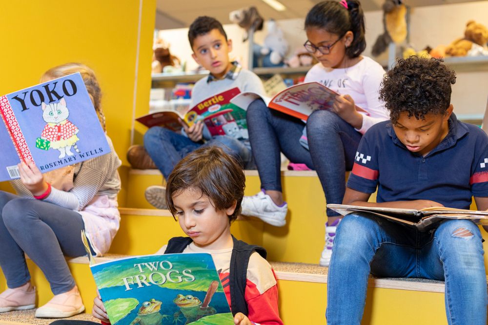 Een groep kinderen leest een boek