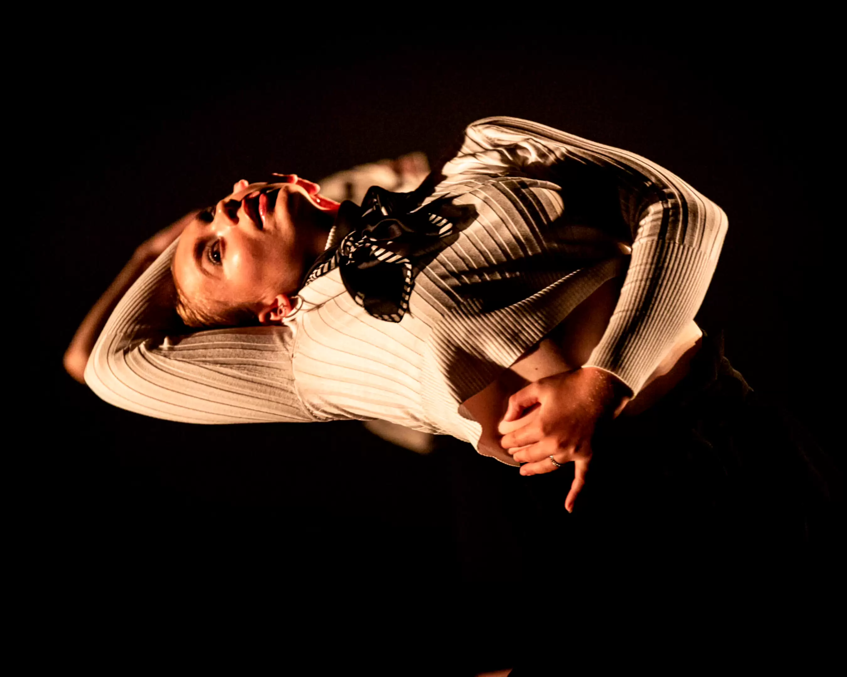 Danseres in een dynamische houding tijdens een intense dansvoorstelling.