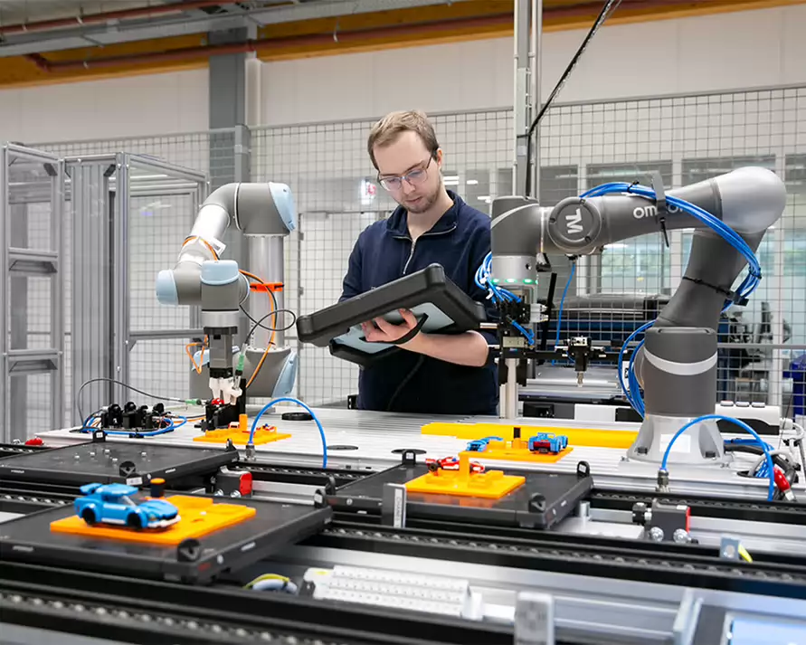 Student ICT in fabriek die een machine programmeert