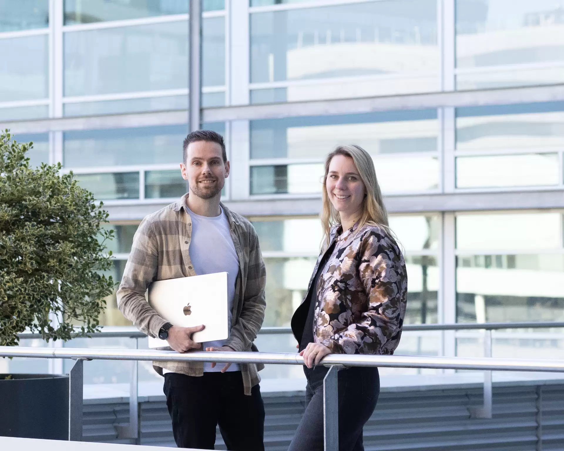 Man en vrouw staan krachtig voor een gebouw