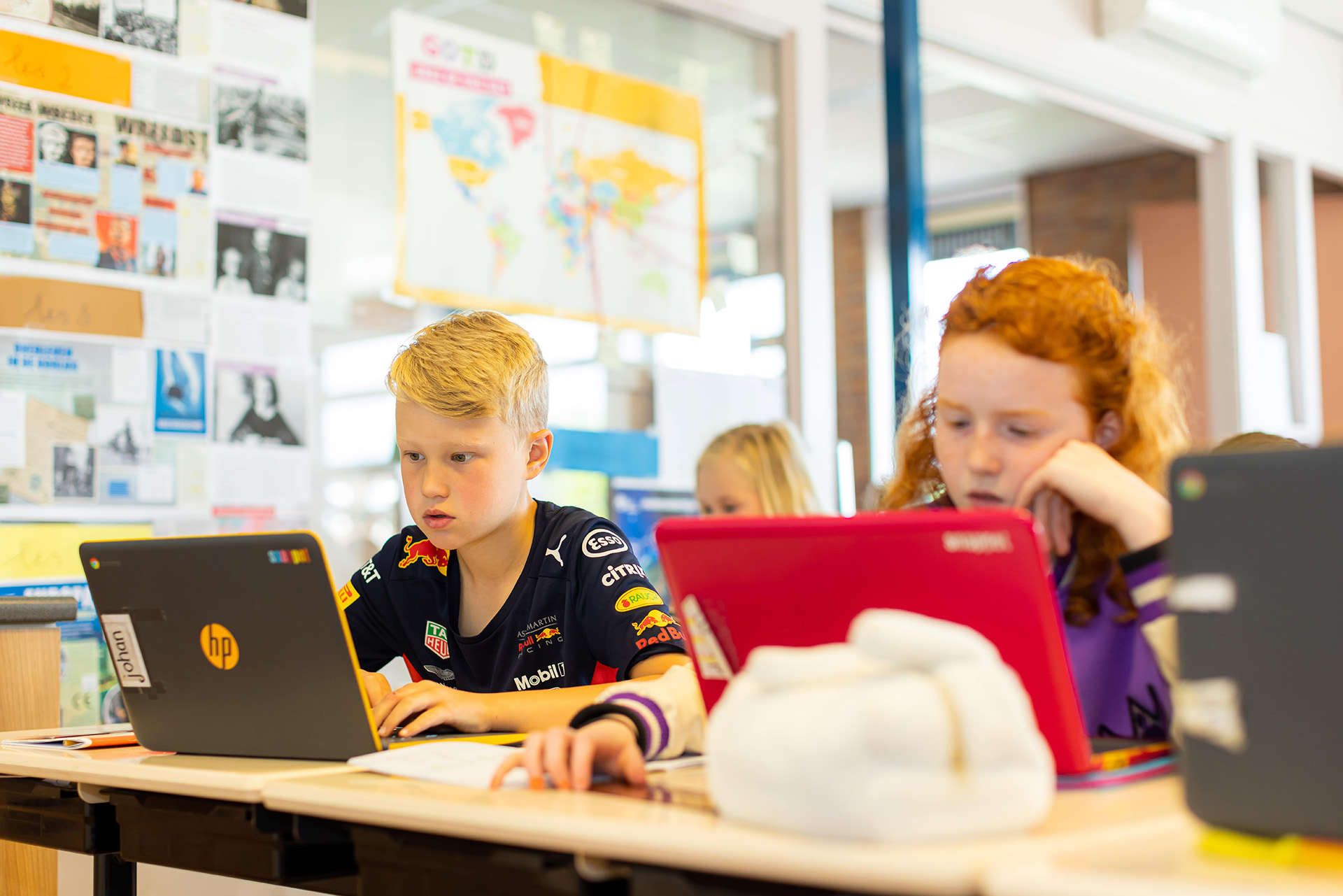 Jonge kinderen die achter hun laptop werken in de klas