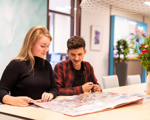 Studenten lerarenopleiding bladeren in een boek