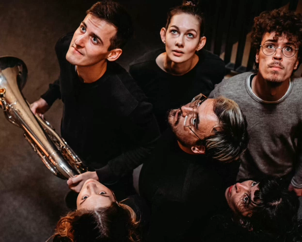 Students perform in public space with several instruments