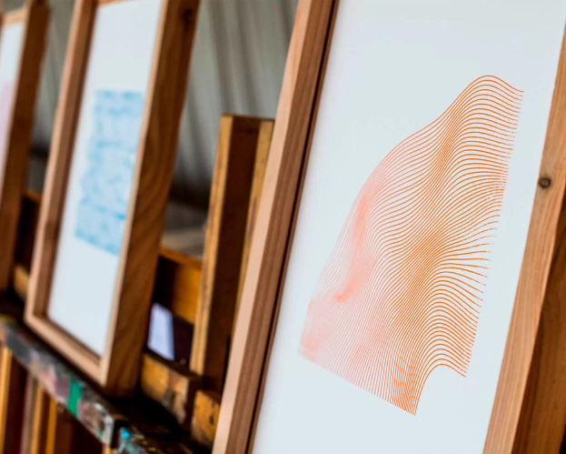 Abstract schilderij met oranje lijnen in een houten lijst.