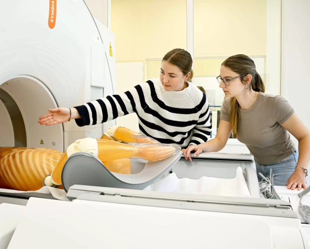 Studenten MBRT bereiden een scan voor met een medisch oefenmodel in een MRI-apparaat.