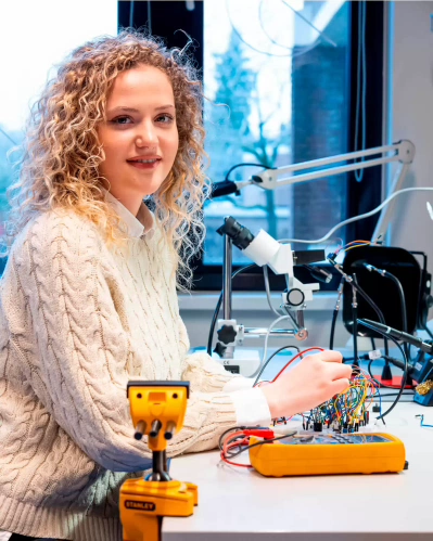 Student in lab with quantum setup and instruments.