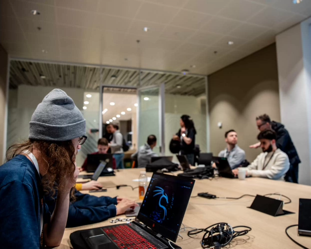 Groep Bachelor ICT studenten werkt samen op hun laptop