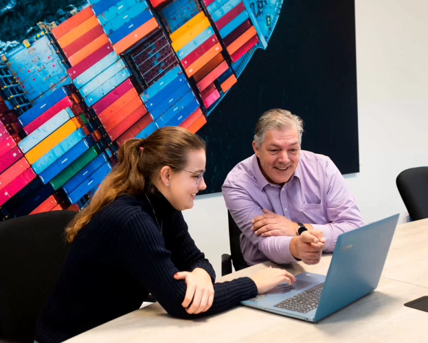 Student en docent die samen werken achter laptop