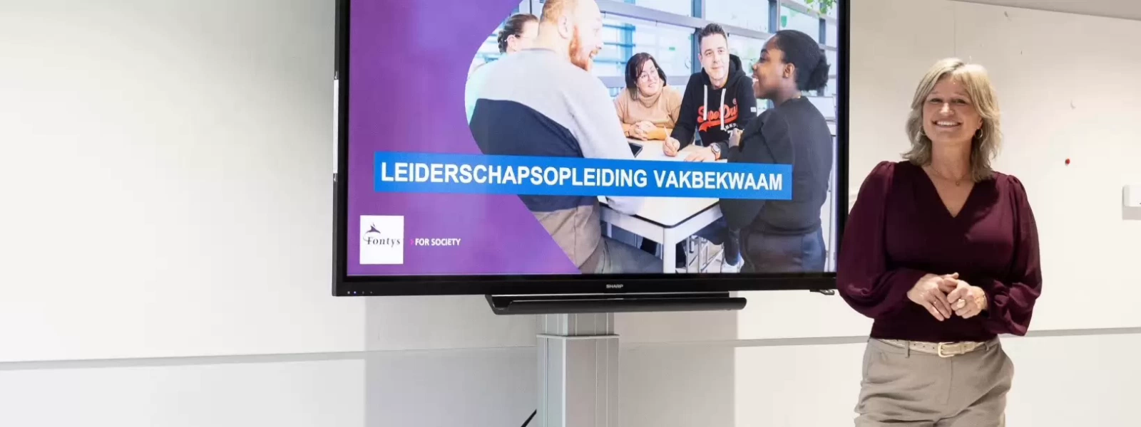 Een groep volwassen die een les volgen in een collegezaal