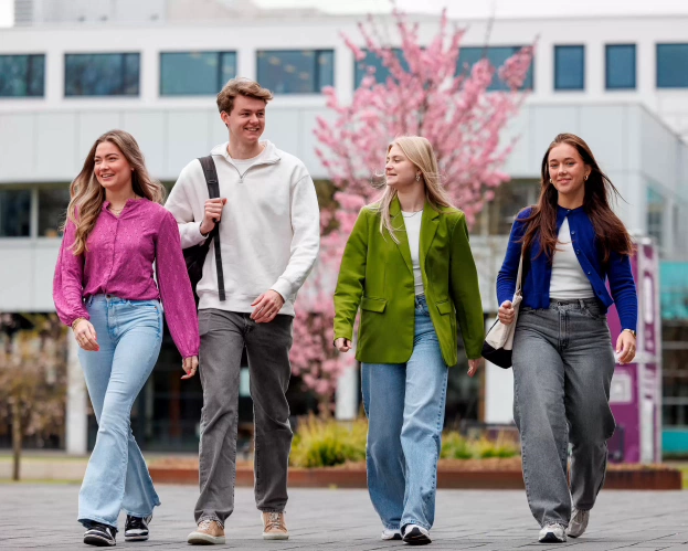 4 studenten lopen over de campus