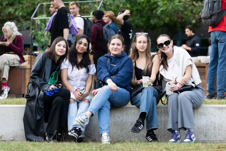 Engelstalige studenten op een bankje op de campus.