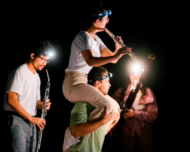 Students perform in a combination of partner acrobatics, flute, bass clarinet and bassoon.