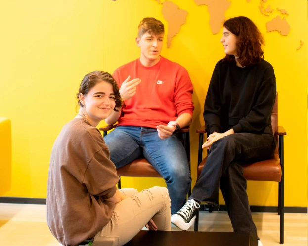 Een student die aan een bureau achter haar computer werkt