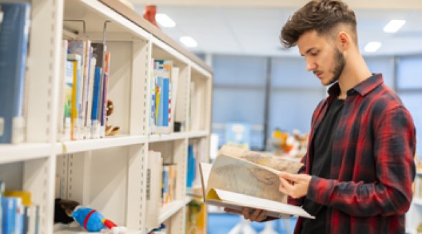 Student leest boek in mediatheek