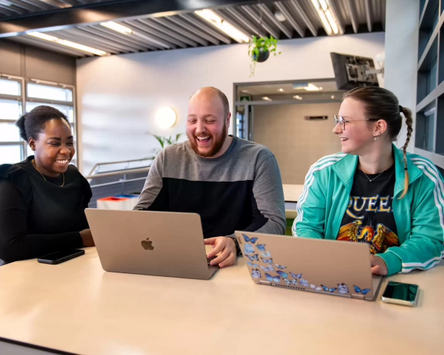 Studenten lachen achter de laptop