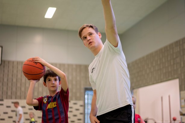 Een student die gymles geeft aan een kind