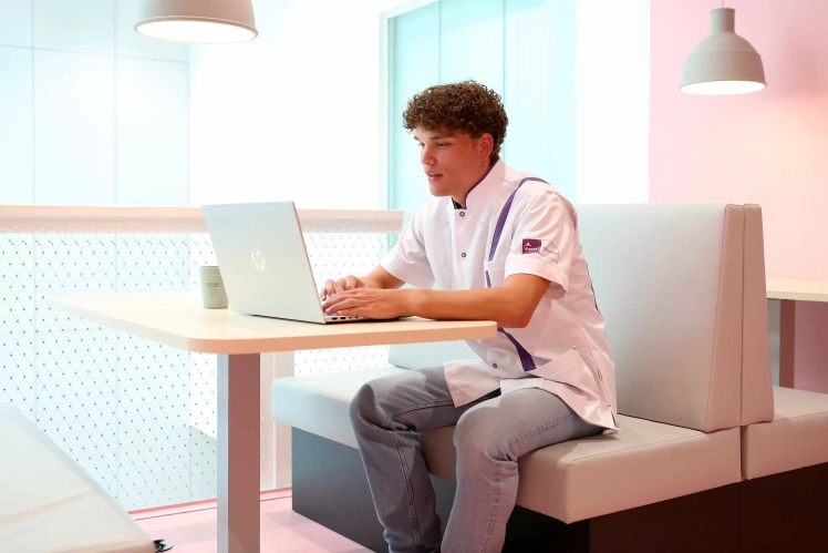 Student van duale Verpleegkunde werkt aan zijn laptop